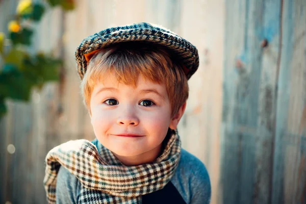 Ragazzo. Faccia emotiva divertente. Bambino con begli occhi che guarda la macchina fotografica. Ragazzo con un cappello di tweed e sciarpa scozzese. Piccolo gentiluomo. Ragazzo felice allegro . — Foto Stock