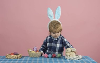 Tüylü tavşan kulakları şirin çocuk tavşan masanın üzerinde çalış. Renkli el yapımı Paskalya süsleri. Oyunlar ve küçük çocuklar için geliştirme. Paskalya arka plan için tatil tebrik kartı