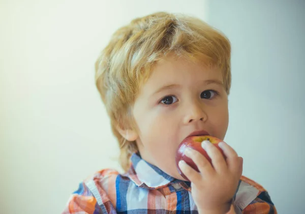 かわいい幼児子供に赤いリンゴを食べるは バレンタインの日に手します 白地に赤のおいしいリンゴと小さな金髪の少年 食物と一緒に子供のポートレート — ストック写真