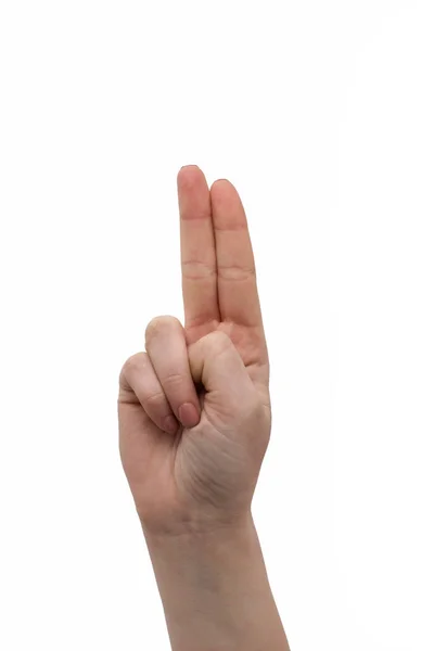 Мир, два пальца вверх, рука об руку или символ победы. Знак буквы V в языке жестов изолирован на белом. Девушка или женщина поднимают два пальца. Женская рука с маникюром подняла два пальца — стоковое фото
