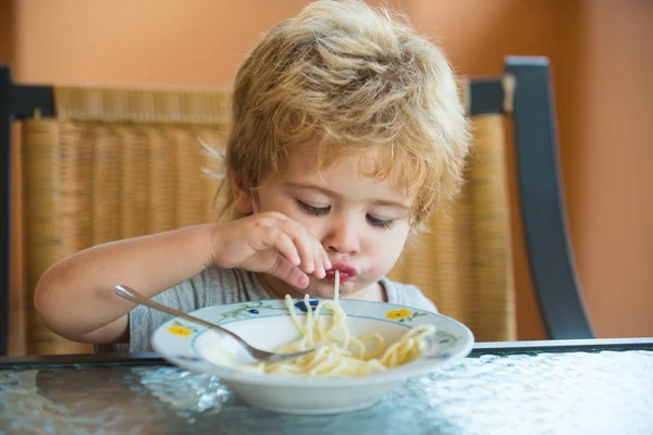 Spaghetti. Baby food. Lunch for kids. A child eats pasta in Italy. Healthy food.