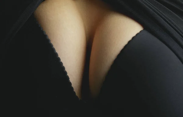 Крупним планом сексуальна жіноча груди в чорному мереживний бюстгальтер. Романтичні, розкішні, чарівні, спокусливі, чуттєві форми. Впишемося вниз. Концепція близькості. Частина тіла сексуальна жіноча груди в чорному бюстгальтері . — стокове фото