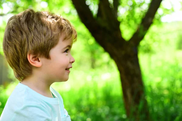 Niño en el fondo de la naturaleza verde. Primavera y alegría. El niño mira hacia otro lado. Retrato. Alergia y polinosis. Hermosa cara de bebé . — Foto de Stock