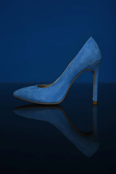 Blue leather shoes on a blue background. Stylish shoes on color background. High heels isolated on a bright pastel background. Fashion concept, catwalk. A modern and fashionable shoe store.