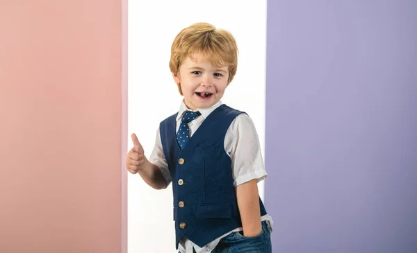 Roztomilý chlapec ukazuje palec. Ten kluk je podnikatel. Úspěšné človíček v obleku. Dohoda. Dítě v džínách a žíly pro školy, student. — Stock fotografie