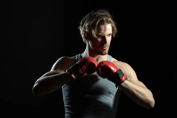 Sexy hombre fuerte guantes de boxeo rojo de vestir. Hombre musculoso en camiseta gris se está preparando para la batalla. Boxeador en el ring. Atractivo chico deportista con guantes rojos — Foto de Stock