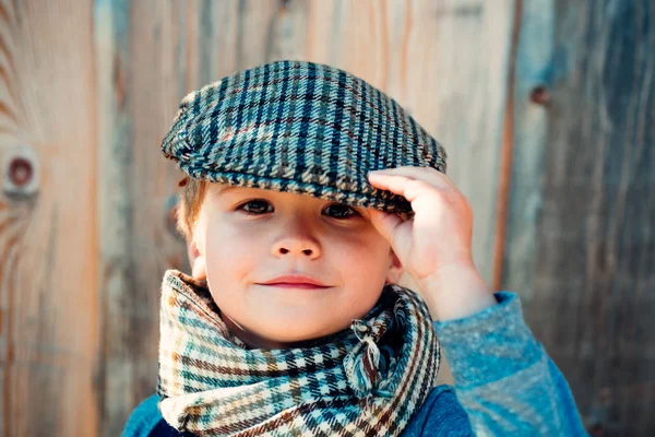 Lindo chico elegante. Chico con gorra. Un niño en un pueblo sobre un fondo de madera. Moda primavera niños . —  Fotos de Stock
