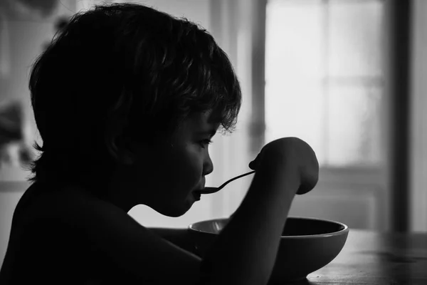 Barnmat. Barn äter med sked. Hälsosam mat för barn. Sommartid. Söt pojke på köket. — Stockfoto