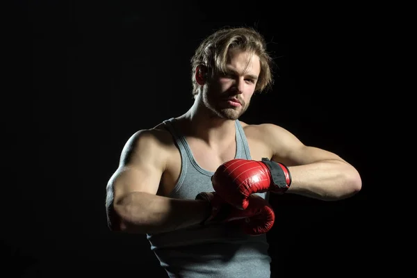 Boxer mira a la cámara. Guantes de boxeo rojos sobre fondo negro. Atractivo deporte chico boxeo aislado — Foto de Stock