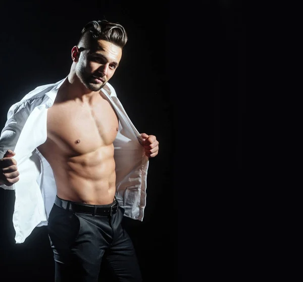 Hombre sexy en camisa blanca con pecho desnudo sobre fondo negro. El barbudo muestra su cuerpo deportivo, abdominales. Ropa para hombre. Empresario por la mañana. Moda masculina. Elegante joven barbudo. Atractivo. — Foto de Stock