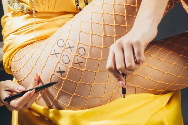 Tic tac toe. Erotická RPG her. Zdobení těla. Kresba těla. Mladá dívka v svůdné punčocháče. — Stock fotografie