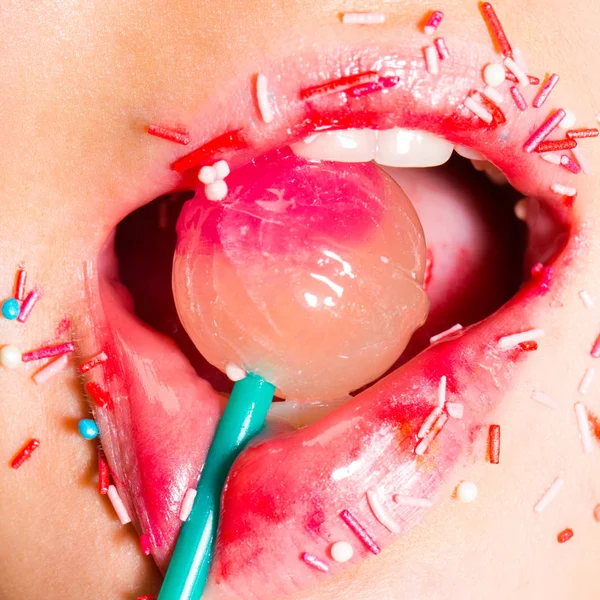Sweet lollipop in the mouth of a young girl. Erotic concept. Seductive sensual mouth. A young woman is sucking a candy. Sugar and temptation, sexy lips and delicious oral sex. Desire. Sexy kiss.