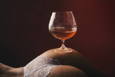 Çıplak kadın kıçında konyak. Bir bardak alkol. Seksi bir akşam. Seksten önce alkol. Stres ve anti-stres. Terapi ve rahatlayın. Akşam zevki. Fahişelik veya çıplak kız kalça.