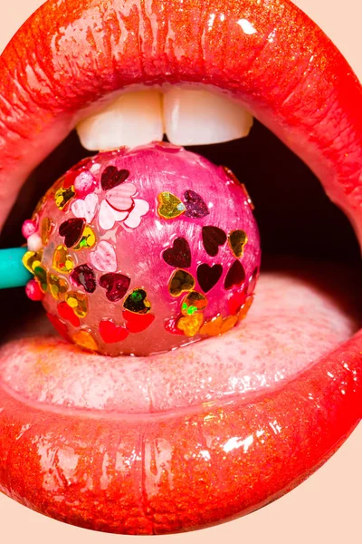 Sucette avec des cœurs dans la bouche. Baiser doux le jour de la Saint Valentin. Caries pour les dents blanches. Des bonbons pour les filles. Séduisante fille offre pipe. Rouge à lèvres rouge et bonbons roses — Photo