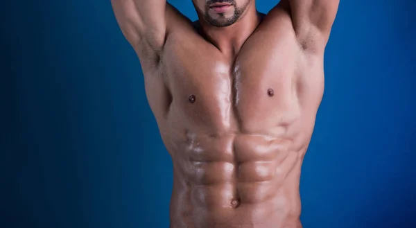 Body of young handsome guy on blue background. Close up of young male models torso with raised hands for gym or competition advertising campaign. Strong naked body with perfect six abs. — Stock Photo, Image