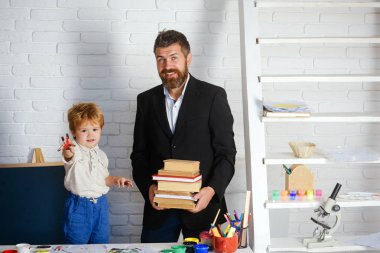 Öğretmen. Eğitim. Bir çocuk için okul. Öğretmen olarak sakallı adam. Çocuklar için kitap ve çizim.