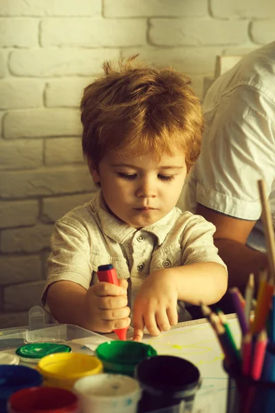 Inteligentne dziecko rysuje. Kreatywne dziecko. Poważny chłopiec rysuje. Młody artysta tworzy obrazek z różowym długopisem i farbami. Wielokolorowe ołówki w szkole lub przedszkolu. Blond dziecko na wakacjach, szczęśliwy dzieciak — Zdjęcie stockowe
