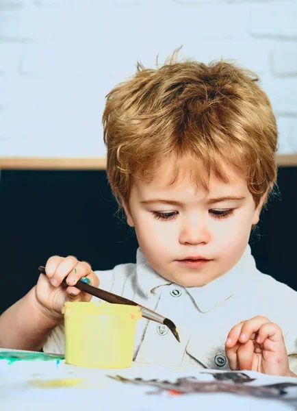 Çocuk yetenekleri, geliştirme, çocuk fırça ile sarı boya çizer, sanat ilgi, çizim sınıfı, küçük okul çocuğu veya anaokulu, resim genç sanatçı, Sanat Galerisi veya stüdyoda Master sınıf