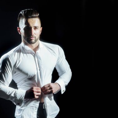 Yakışıklı adam onun beyaz gömlek siyah arka plan karşı dururken kadar düğmelerini. Güzel şekil şık yakışıklı genç adam. İşadamı elbise gömlek