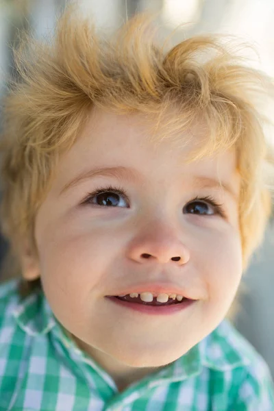 Feliz niño alegre, hermoso niño pequeño cara de cerca. Felicidad en la cara de los niños, centro de niños para el desarrollo y juegos divertidos. Chico mira hacia arriba, sonríe con dientes blancos, salud del bebé — Foto de Stock