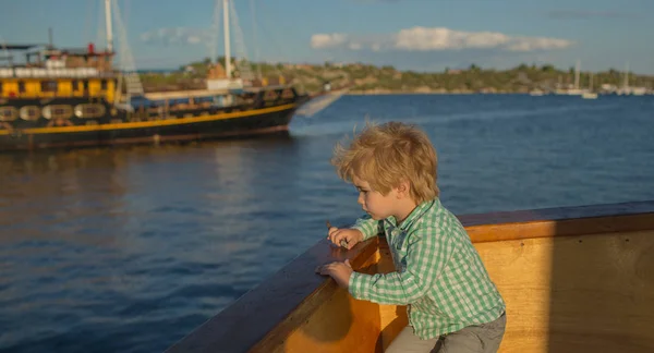 Niño en la cubierta del barco. Viajar por mar. Un pequeño turista, vacaciones y vacaciones. Naves en el mar. Lindo marinero. Un niño y sus aventuras en el mar — Foto de Stock