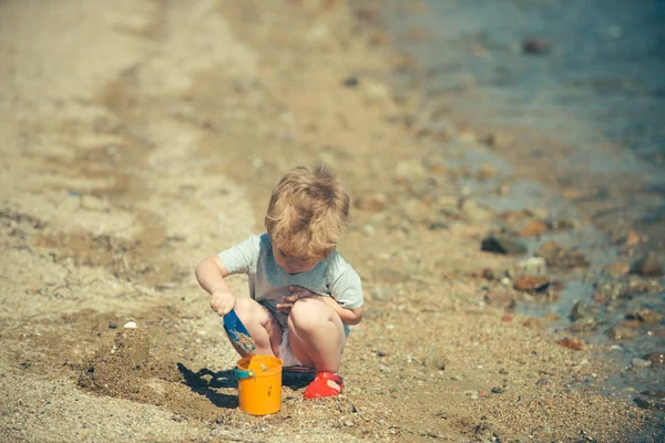 Children playing on the beach with space for text. Cute little kid boy play with sand on beach. Vacation. Time at sea. — Stock Photo, Image