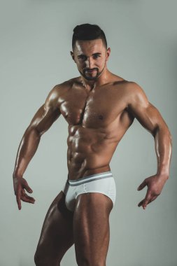 Kendine güvenen sakallı adam kameraya bakar ve poz lar. Ciddi baştan çıkarıcı genç adam onun samimi eğlenceli duygular gösterir. Vücut geliştirme iyi eğitimli kişiden poz. Protein diyeti ve günlük eğitimler.