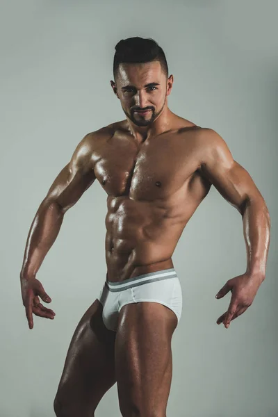 Confident bearded man look at camera and poses. Serious seductive young guy shows his sincere fun emotions. Bodybuilding pose from well trained person. Protein diet and daily trainings. — Stock Photo, Image