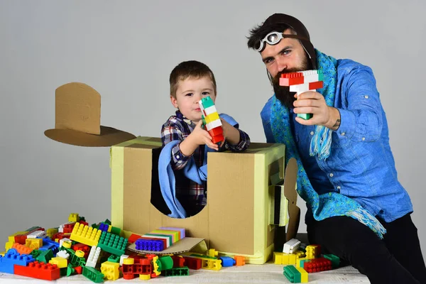 Two gangsters play with plastic guns. Child and relative constructed small guns from cubes. Family leisure together. Curious and developing activities for parents and children. Father and son together — Stock Photo, Image