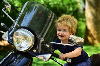Motosikletteki mutlu küçük sürücü. Yol ve seyahat. Bir motorcu ve mutlu bir yaz tatili. Macera için ulaşım. Motosikletli güzel çocuk