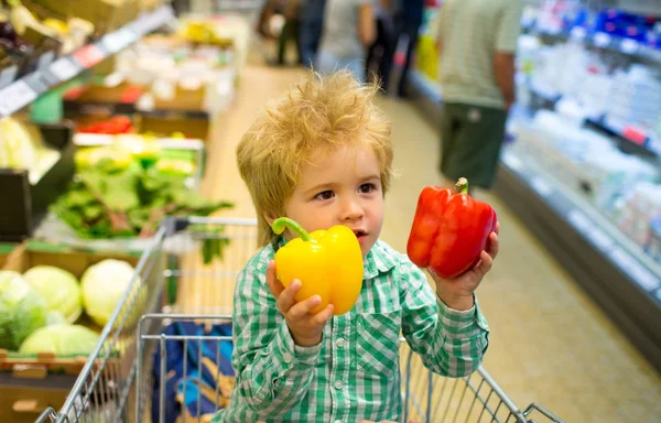 Vegetables. Organic Shop. Vegan Organic Food, Produce of pepper. Cute child holds grocery shopping, fresh vegetables. Diet healthy eating concept.