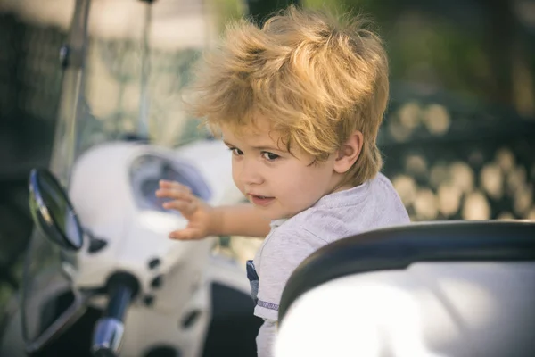 Pequeño conductor. El chico conduce un coche de juguete . — Foto de Stock