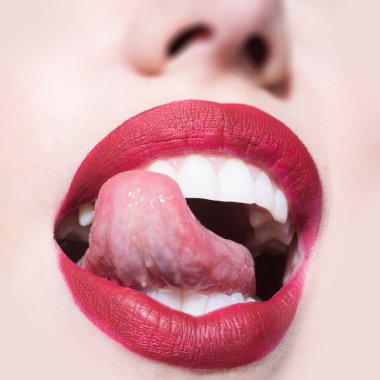 White teeth of beautiful young women. Open female mouth with red lipstick. Seductive ladys mouth open and red lips close up. Sexy red lips. Glamour and sensual make up for ladies. Girl face close up