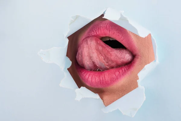 Close-up de lábios femininos sexy com língua. A pele limpa e um contorno de lábio claro traçam-se com um batom na moda. Dentes brancos e o sorriso de beleza, spa ou cosmetologia. Beijo de paixão . — Fotografia de Stock