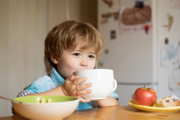 Buvez. Une nourriture saine. L'enfant boit dans une grande tasse. Déjeuner pour les enfants . — Photo