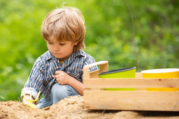 Garden. A boy in the garden digs a bed. Land for vegetables. Healthy food. Farm. Farmer. The little farmer and the ground. — Stock Photo, Image