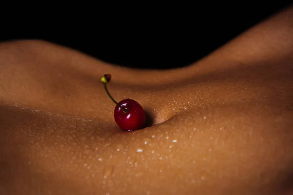Frauenbauch. Kirsche auf dem Bauch. sexy Frucht. — Stockfoto