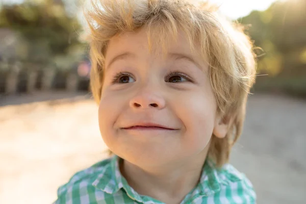 Kinderen portret glimlachen. Portret van het kind. Grappige kleine jongen op natuur achtergrond. Schattige jonge gelukkige jongen met glimlach. Gelukkig vrolijke mooie kleine jongen. Schattige baby in groen shirt close-up — Stockfoto