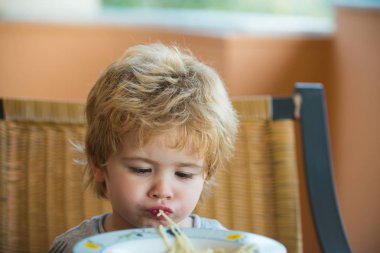 Lezzetli spagetti. Çocuk makarna yiyor. İtalyan yemeği. Çocuk beslenmesi.