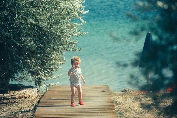 海の近くの子供青い海水を背景にした少年。ギリシャの夏休み. — ストック写真