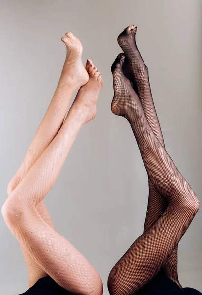 Жіночі ноги. Двоє друзів догори ногами. Вправи проти варикозу. Нижня білизна і колготки. Жіноча концепція. Дві дівчини, лесбіянки. Красиві олов'яні ноги вгору — стокове фото