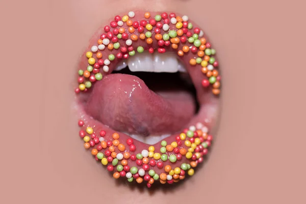 Süßer Lippenstift. Kreatives Make-up. Bonbons auf weiblichen Lippen. Farbkosmetik. weibliche Lippen. — Stockfoto