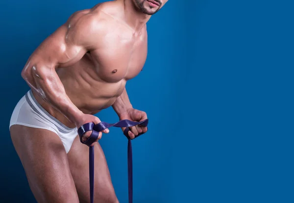 Seductive males fit body close up. Man training in white underwear. Example of confdent person working hard on his body. Muscular body close up with sport equipment. Advertising campaign of sport.