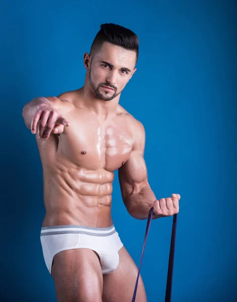 Naked man finger pointing at camera. Athlete does exercises and shows success. Demonstration of success, beautiful strong body with muscles from gym. Personal trainer with naked torso in white shorts