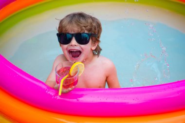 Mutluluk. Yaz istirahati. Çocuk zevkle bağırıyor. Gülün ve gülümse. Havuzdaki çocuk. Çocuk yaz kokteyli içiyor. Tatil köyünde zevk. Çocuk sağlığı.