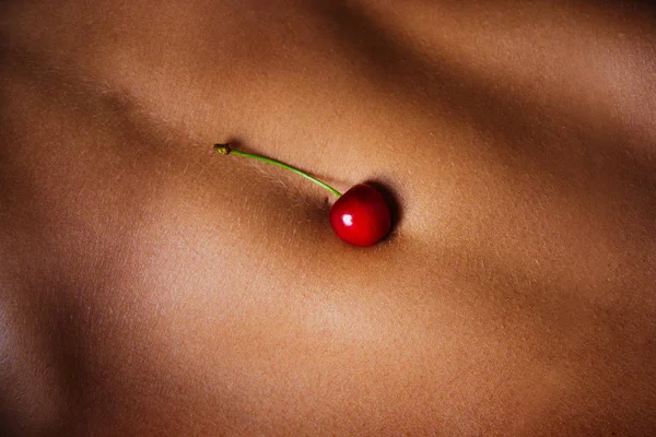 Músculos abdominales. Deportiva de cerca. Vientre con cerezas. Baya roja en el cuerpo femenino. Foto seductora. Piel sensual. Concepto de Cosmética de Frutas. Gimnasio y equipo de fitness femenino para una figura perfecta . —  Fotos de Stock