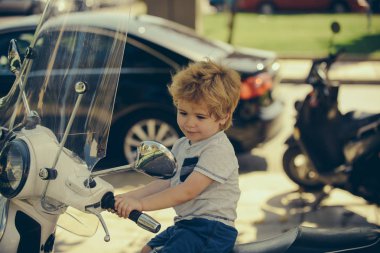 Motosikletteki sevimli bebek. Yaz gezisi. Macera. Seyahat için ulaşım. Küçük şoför. Büyük çocuk konsepti. Mutlu yaz tatilleri.