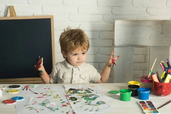 Children art. Happy painting. The child is preparing for school. Boy with paints.