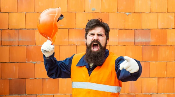 Protest. The builder screams. A man in a protective yellow vest. Salary. Strike. Low pay. Hard work. Handyman. Foreman at a construction site angry and aggressive.