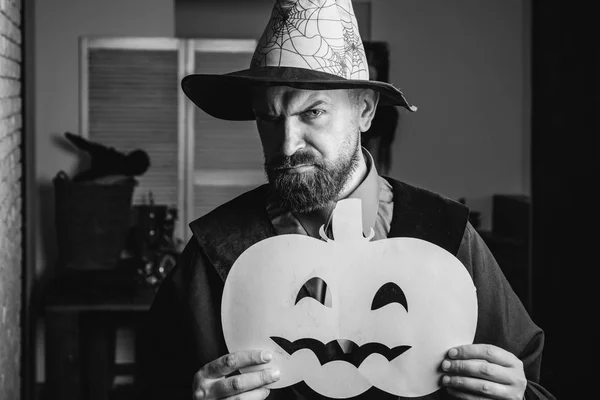 Halloween costume with pumpkin. A wizard with a bearded, attractive man in a sorceress costume. Tool on Halloween party. Sexy magic. The wizards cap. — Stock Photo, Image